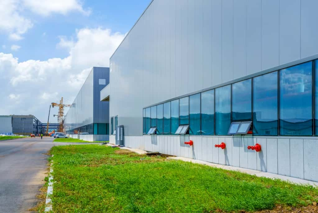 Industrial building with blue windows under construction on a sunny day