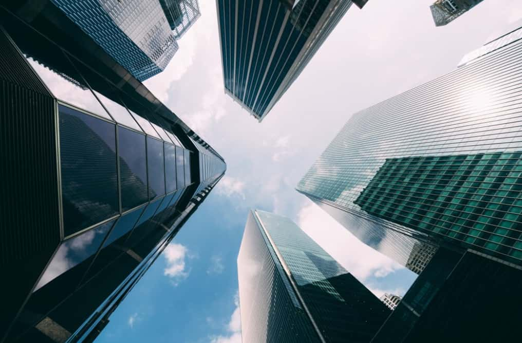 Looking up at towering skyscrapers against a backdrop of blue sky and clouds