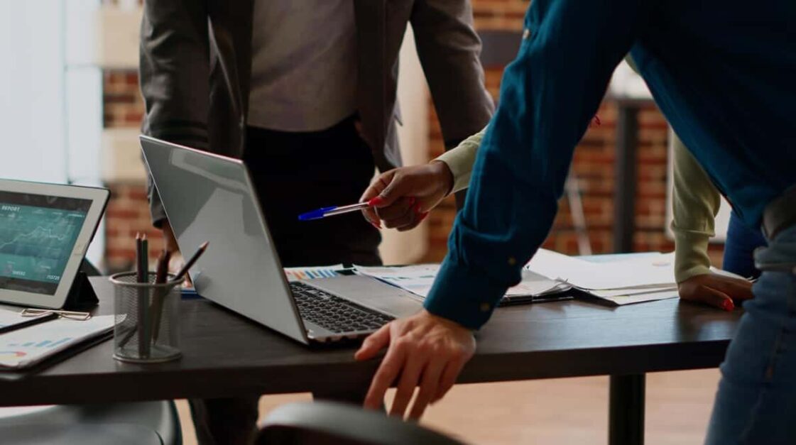 Two professionals analyzing data on a laptop in an office