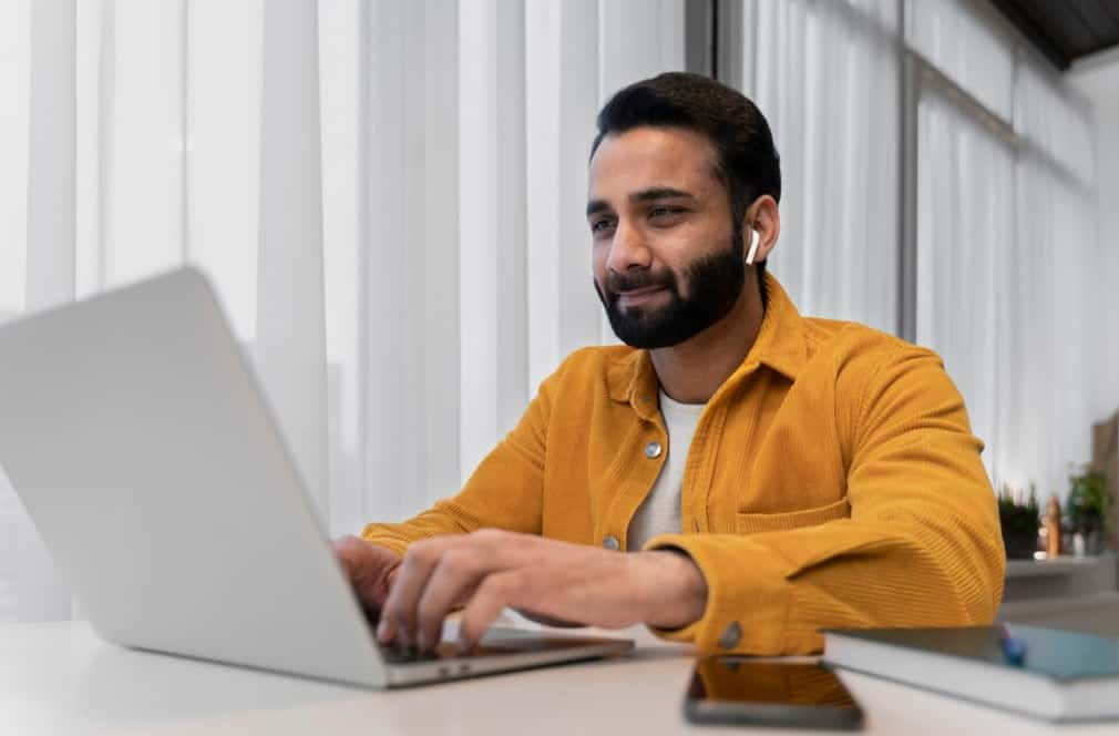 A content professional working on a laptop with earphones